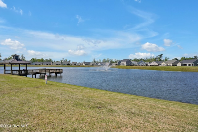 dock area featuring a gazebo, a water view, and a yard