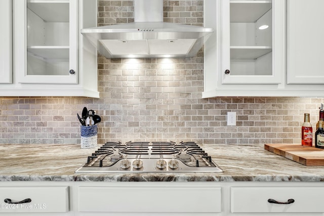 kitchen with tasteful backsplash, stainless steel gas stovetop, and ventilation hood