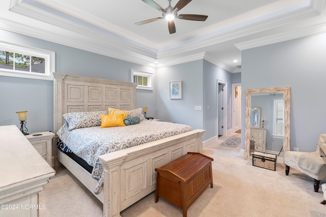 carpeted bedroom featuring crown molding, a tray ceiling, and ceiling fan