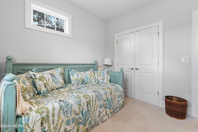 bedroom with a closet and light colored carpet