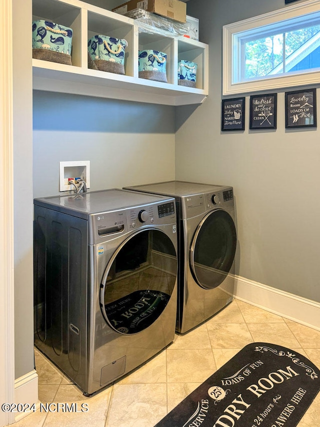 laundry room featuring washer and dryer and light tile patterned flooring