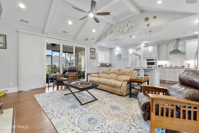 living room featuring ceiling fan, high vaulted ceiling, beamed ceiling, and light hardwood / wood-style flooring