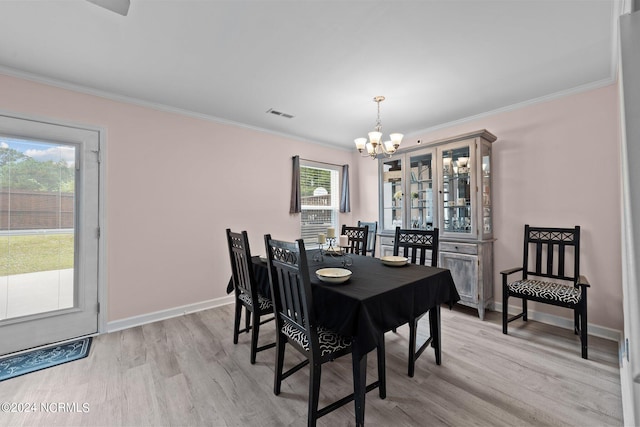 dining area with a notable chandelier, light hardwood / wood-style floors, and crown molding