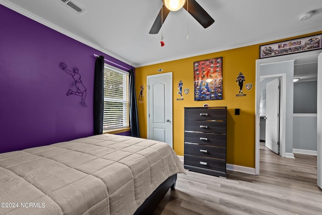 bedroom with light hardwood / wood-style floors, ceiling fan, and crown molding