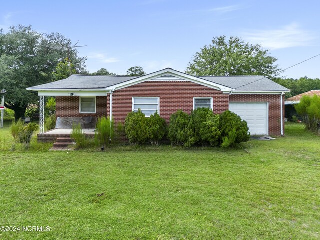 view of front of house with a front lawn and a garage