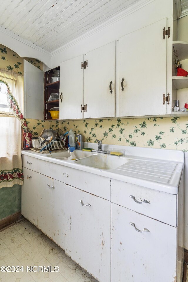 kitchen with crown molding, wooden ceiling, and white cabinetry