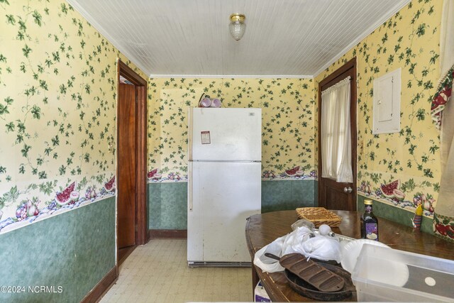 kitchen with ornamental molding, electric panel, and white fridge