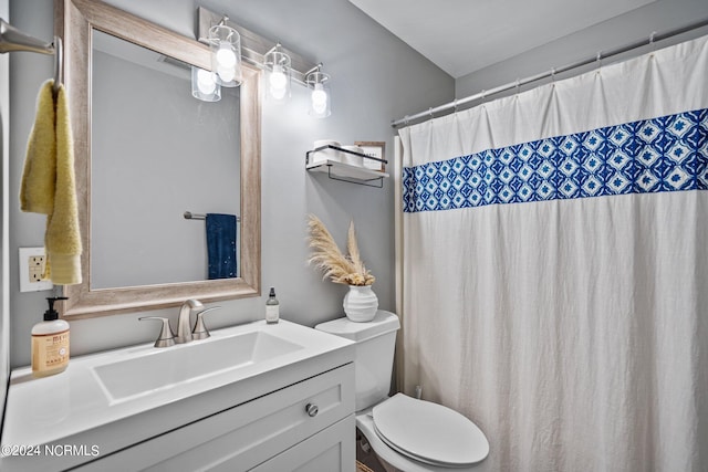 bathroom featuring walk in shower, vanity, and toilet