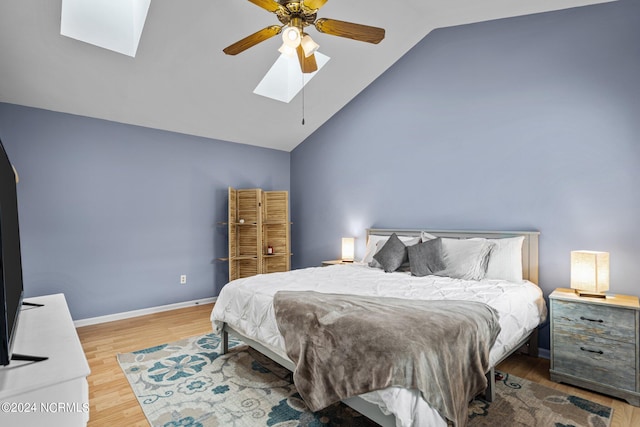 bedroom with wood-type flooring, ceiling fan, and vaulted ceiling with skylight