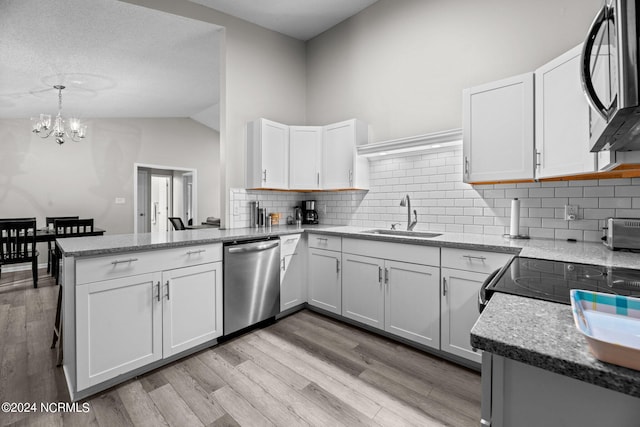 kitchen with stainless steel appliances, sink, kitchen peninsula, and white cabinetry