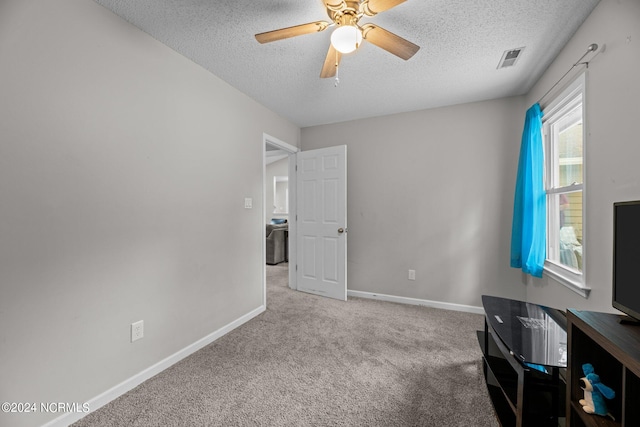 interior space featuring a textured ceiling, light carpet, and ceiling fan