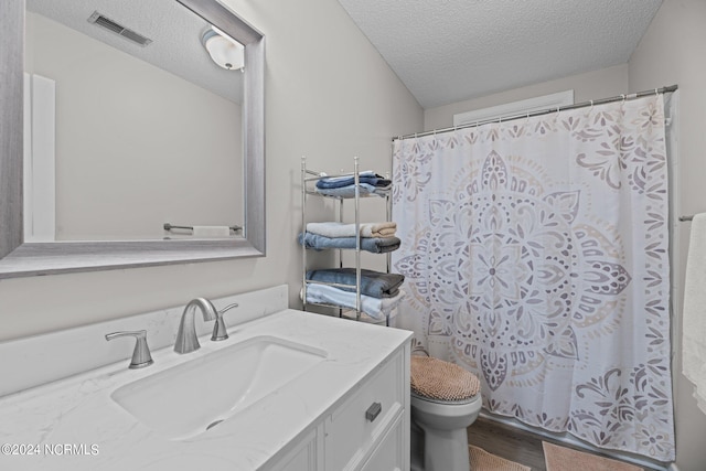 bathroom featuring vanity, wood-type flooring, a textured ceiling, a shower with curtain, and toilet