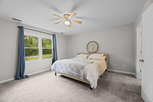 bedroom featuring ceiling fan, a textured ceiling, and carpet