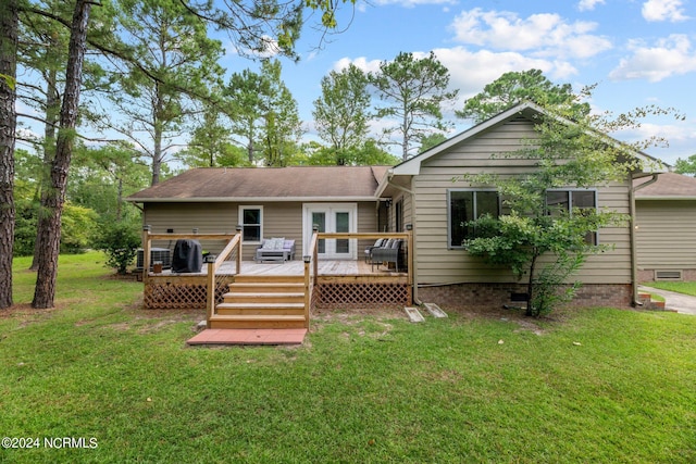 rear view of house with a wooden deck and a lawn