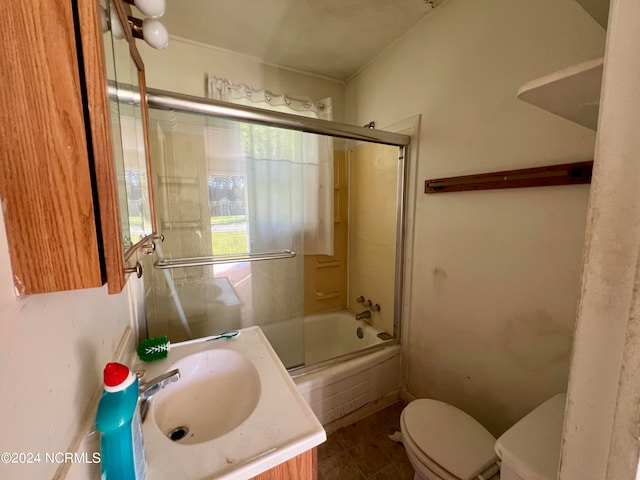 full bathroom featuring tile patterned flooring, vanity, toilet, and bath / shower combo with glass door