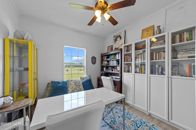 home office featuring crown molding, ceiling fan, and light wood-type flooring