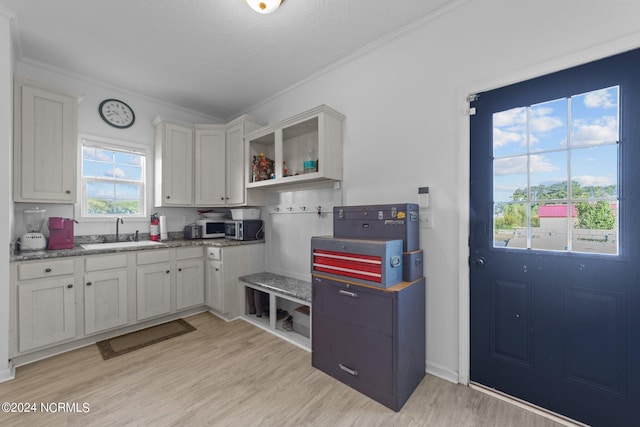 kitchen featuring white cabinets, light hardwood / wood-style floors, and sink