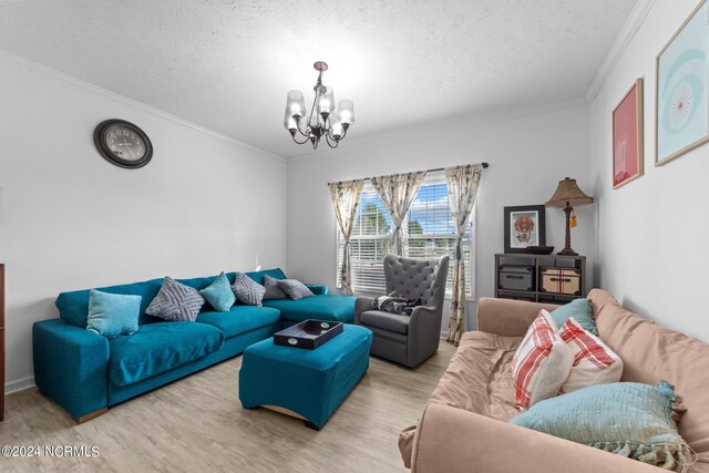 living room featuring a chandelier, ornamental molding, a textured ceiling, and light hardwood / wood-style flooring