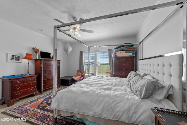 bedroom featuring ceiling fan, crown molding, and a textured ceiling