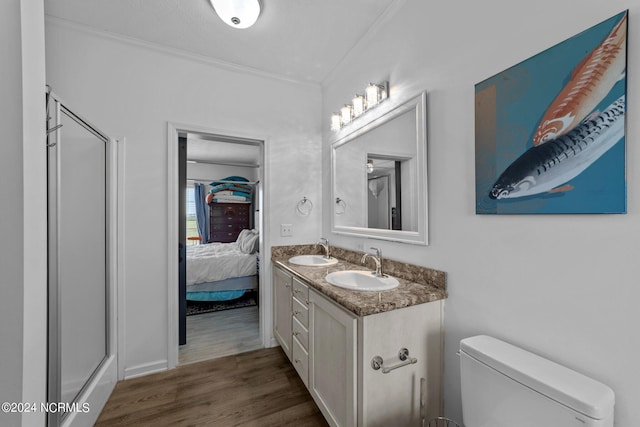 bathroom featuring an enclosed shower, vanity, crown molding, hardwood / wood-style flooring, and toilet