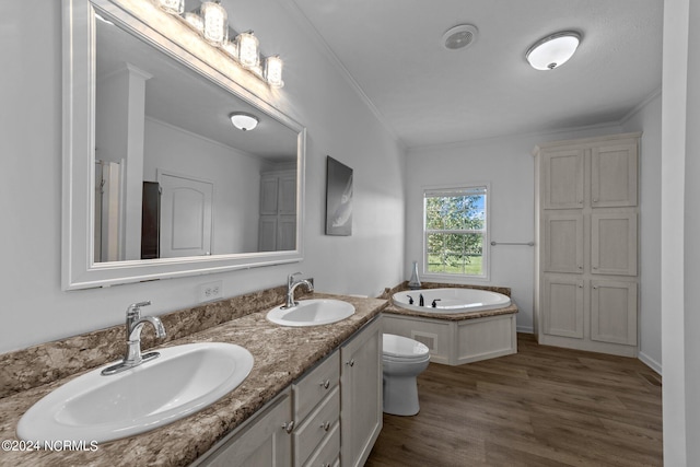 bathroom featuring ornamental molding, vanity, a bath, hardwood / wood-style flooring, and toilet