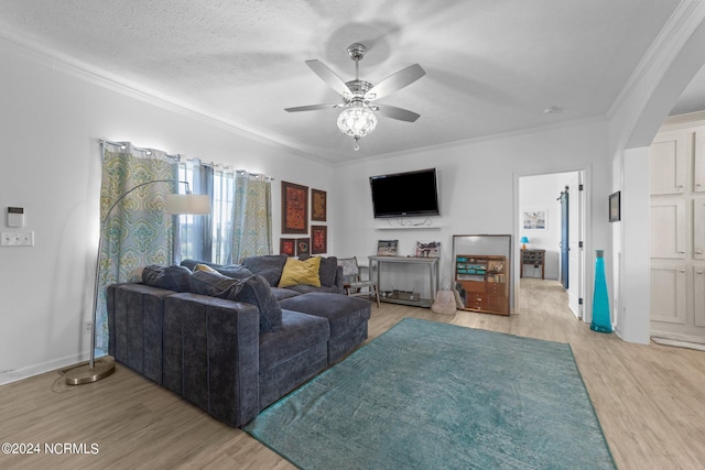 living room featuring a textured ceiling, light hardwood / wood-style flooring, ceiling fan, and crown molding