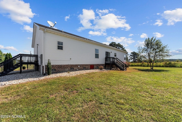 back of house featuring a wooden deck and a yard