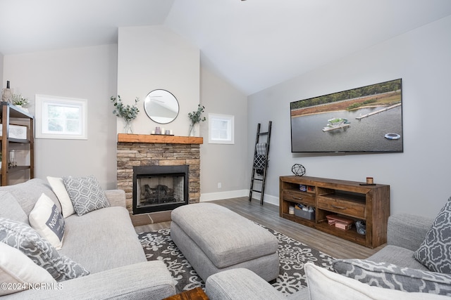 living room with a stone fireplace, vaulted ceiling, and hardwood / wood-style floors