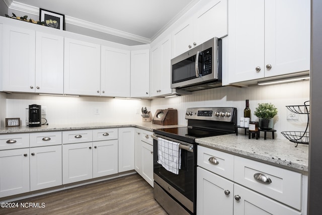 kitchen featuring light stone counters, ornamental molding, white cabinetry, appliances with stainless steel finishes, and dark hardwood / wood-style flooring