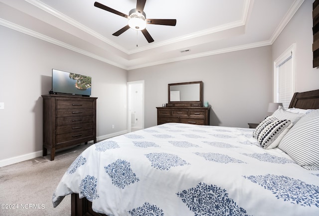 bedroom with ceiling fan, a tray ceiling, light carpet, and ornamental molding