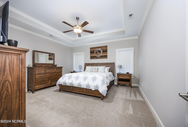 carpeted bedroom with ceiling fan, a raised ceiling, and crown molding