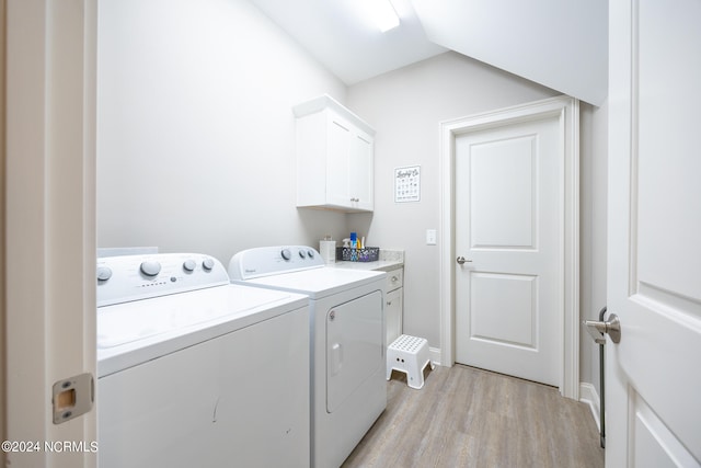 laundry room featuring cabinets, light hardwood / wood-style floors, and washer and dryer