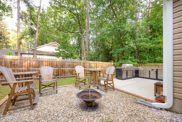 view of patio with a fire pit, sink, an outdoor kitchen, and a grill