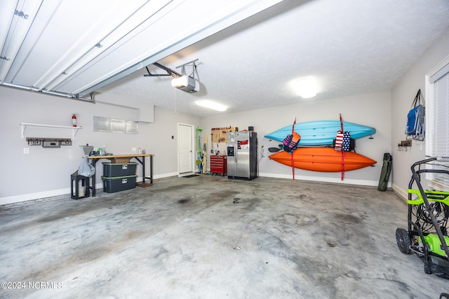 garage featuring stainless steel refrigerator with ice dispenser and a garage door opener