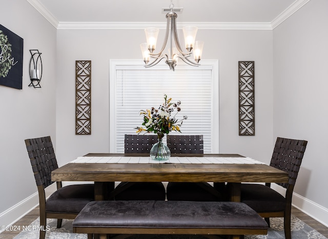 dining space with ornamental molding, a notable chandelier, and hardwood / wood-style floors