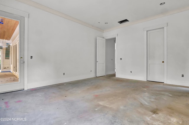 empty room featuring crown molding and concrete flooring