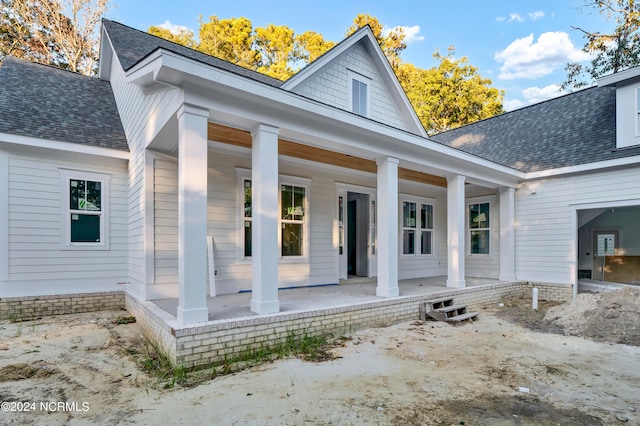 rear view of house featuring covered porch