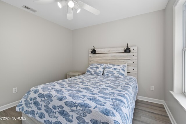 bedroom with ceiling fan, two closets, and light wood-type flooring