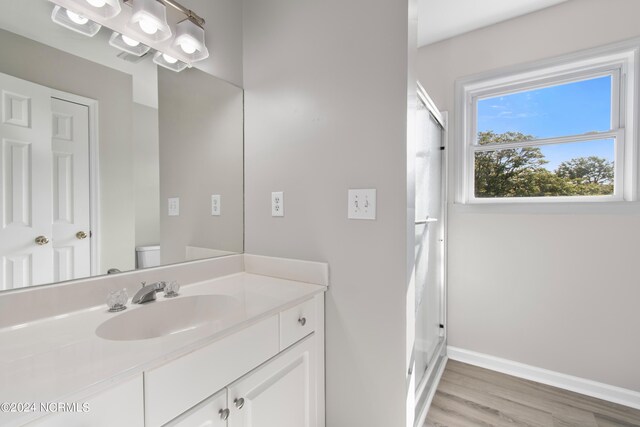 bedroom with ceiling fan, access to exterior, light wood-type flooring, and connected bathroom