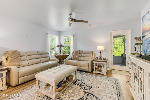 living room featuring light hardwood / wood-style flooring, ceiling fan, and plenty of natural light