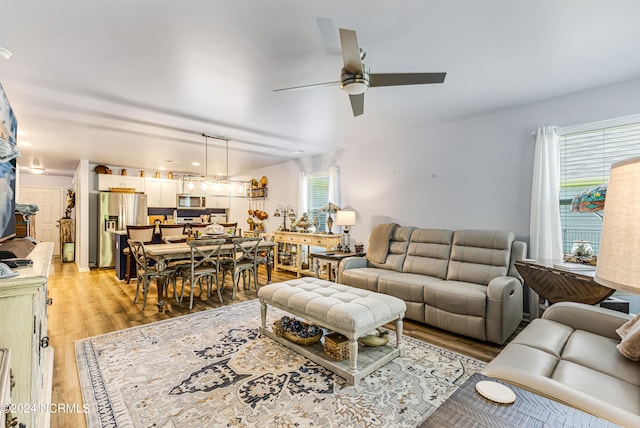 living room with ceiling fan and light hardwood / wood-style flooring