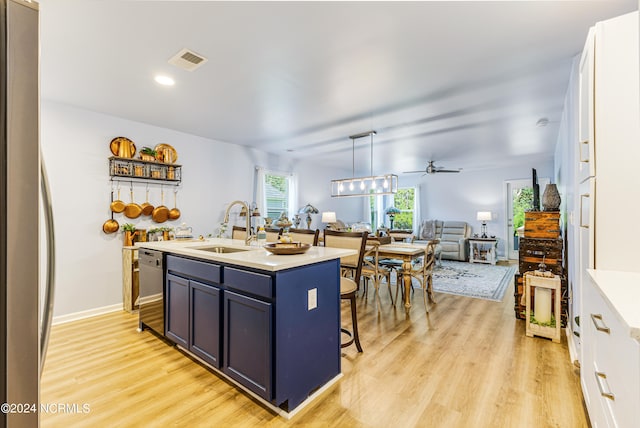 kitchen with a kitchen breakfast bar, a center island with sink, white cabinetry, and pendant lighting