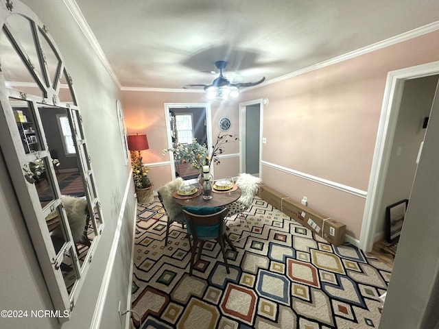 dining space with ornamental molding and ceiling fan