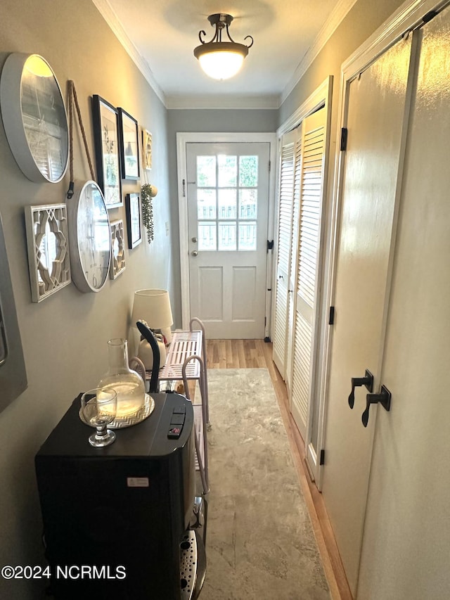 doorway featuring light hardwood / wood-style flooring and ornamental molding