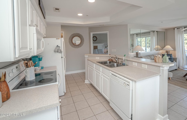 kitchen with an island with sink, white cabinets, white appliances, and sink