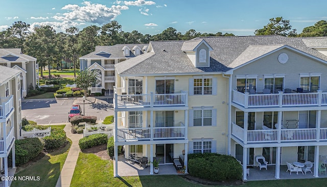 rear view of property with a balcony and a patio area