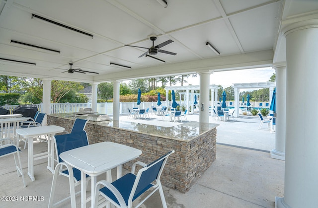 view of patio / terrace featuring ceiling fan and a bar