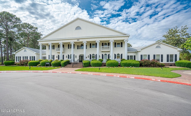 neoclassical / greek revival house featuring a front lawn and covered porch