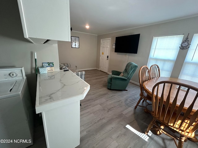 interior space with light hardwood / wood-style flooring, white cabinetry, washer / clothes dryer, light stone countertops, and crown molding