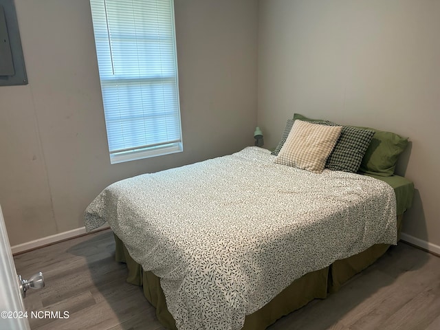 bedroom featuring hardwood / wood-style floors and electric panel